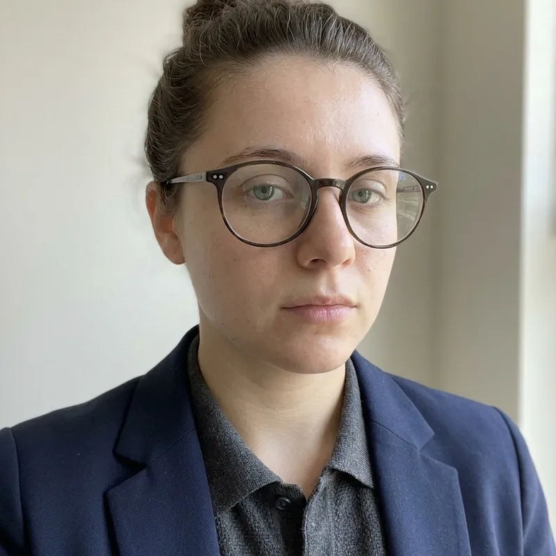 The same woman after the glow-up: clearer healthy skin, tidier hair, her glasses kept, still clearly herself